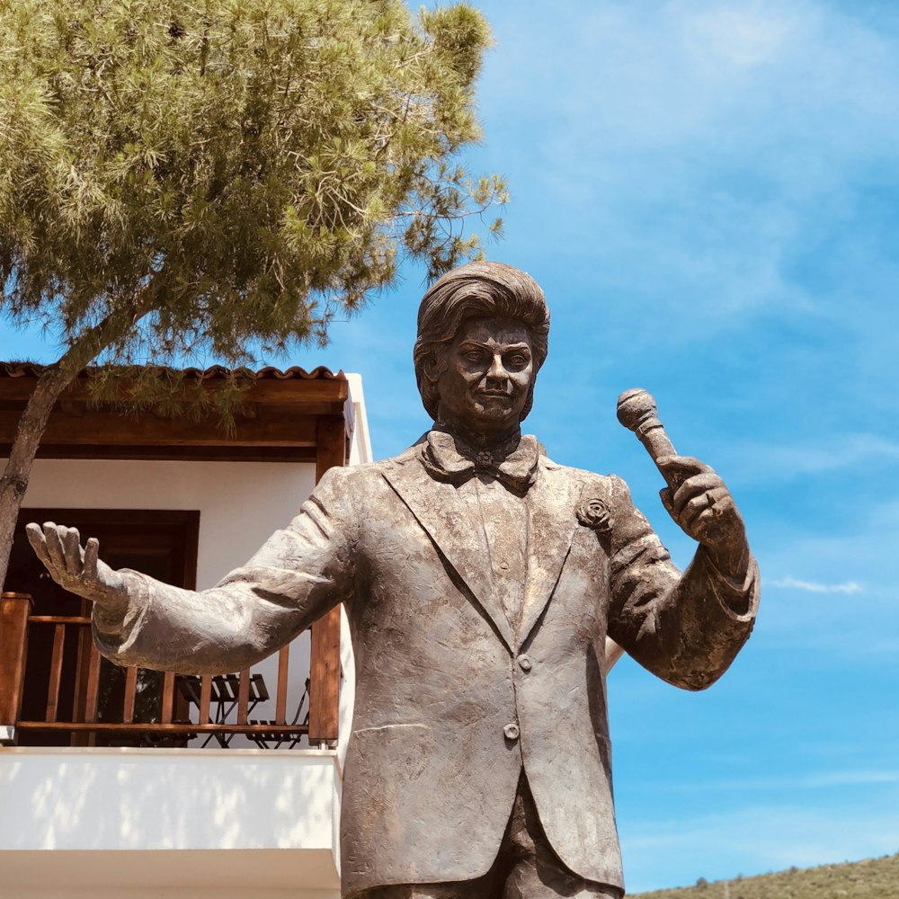 man holding microphone statue