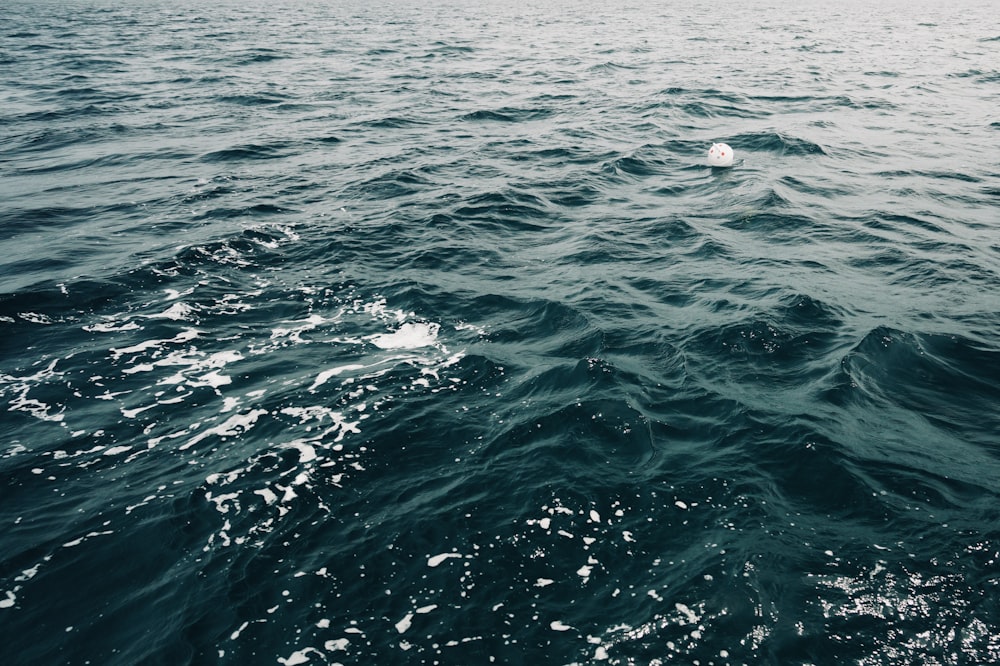 a large body of water with a small boat in the distance