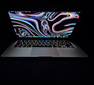 A vibrant digital painting displayed on a laptop screen with colorful brush strokes.