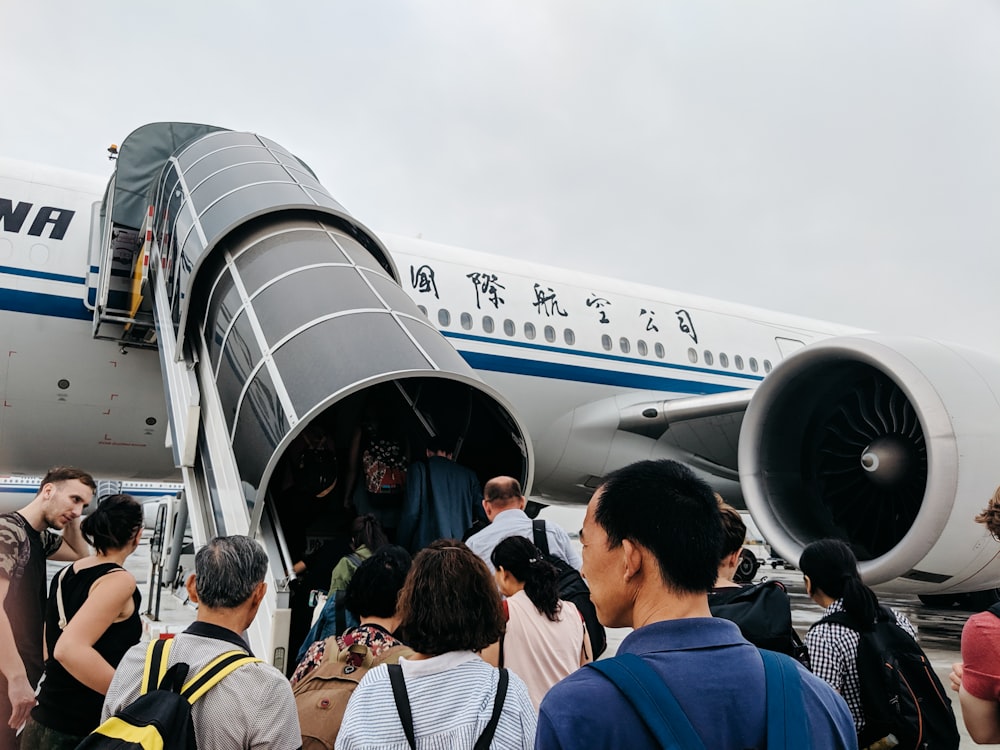 persone che camminano verso l'aeroplano durante il giorno