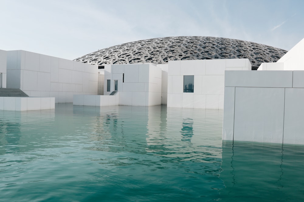 white concrete structure beside body of water