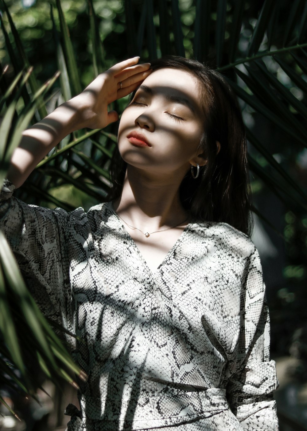 shallow focus photo of woman in white and black snakeskin long-sleeved shirt