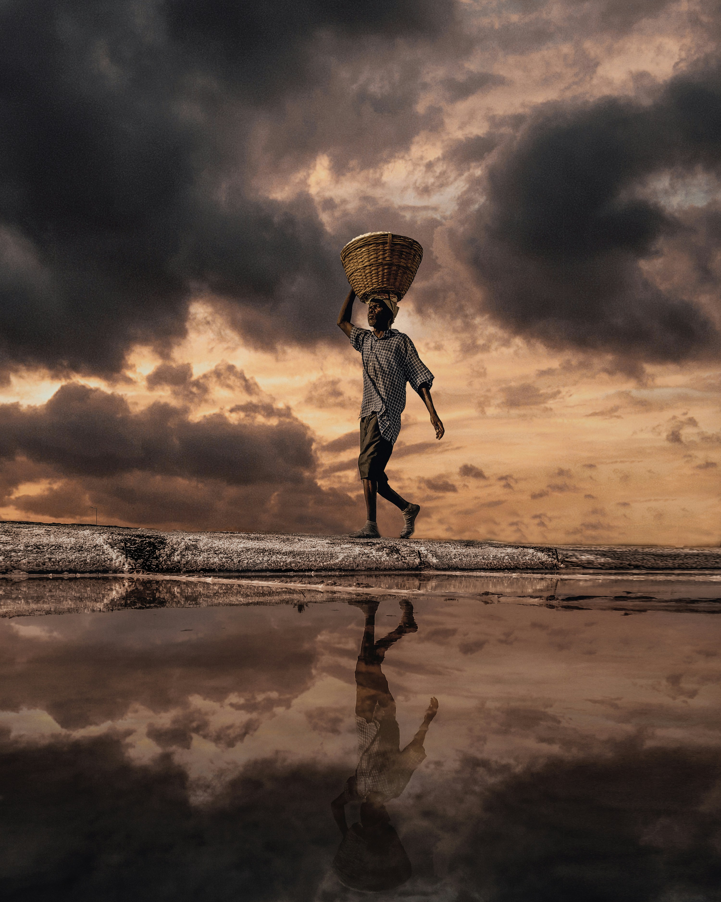 man walking on shore carrying basket