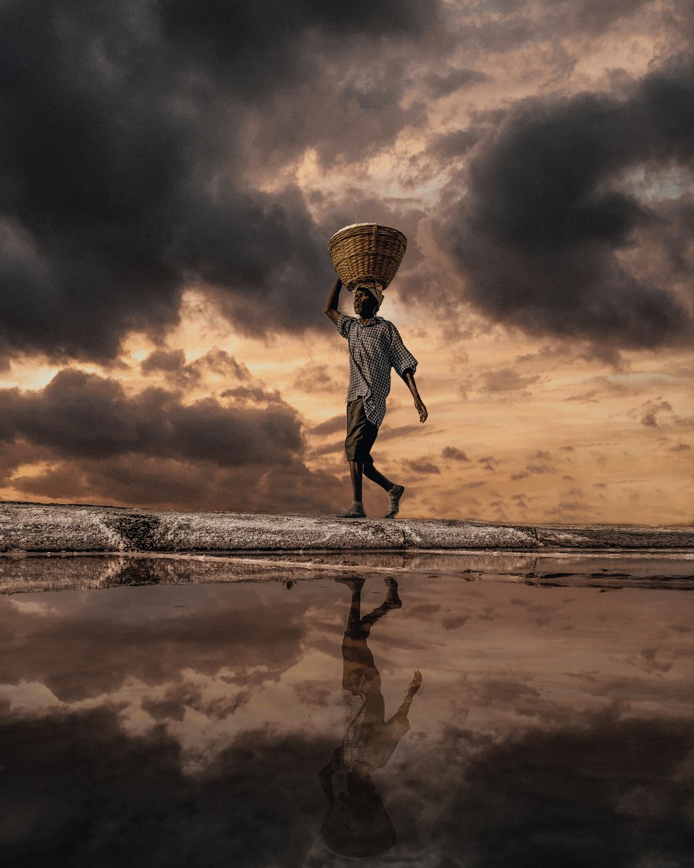 man walking on shore carrying basket