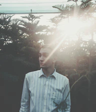 A young professional enjoying a peaceful moment outdoors, sunlight filtering through trees.