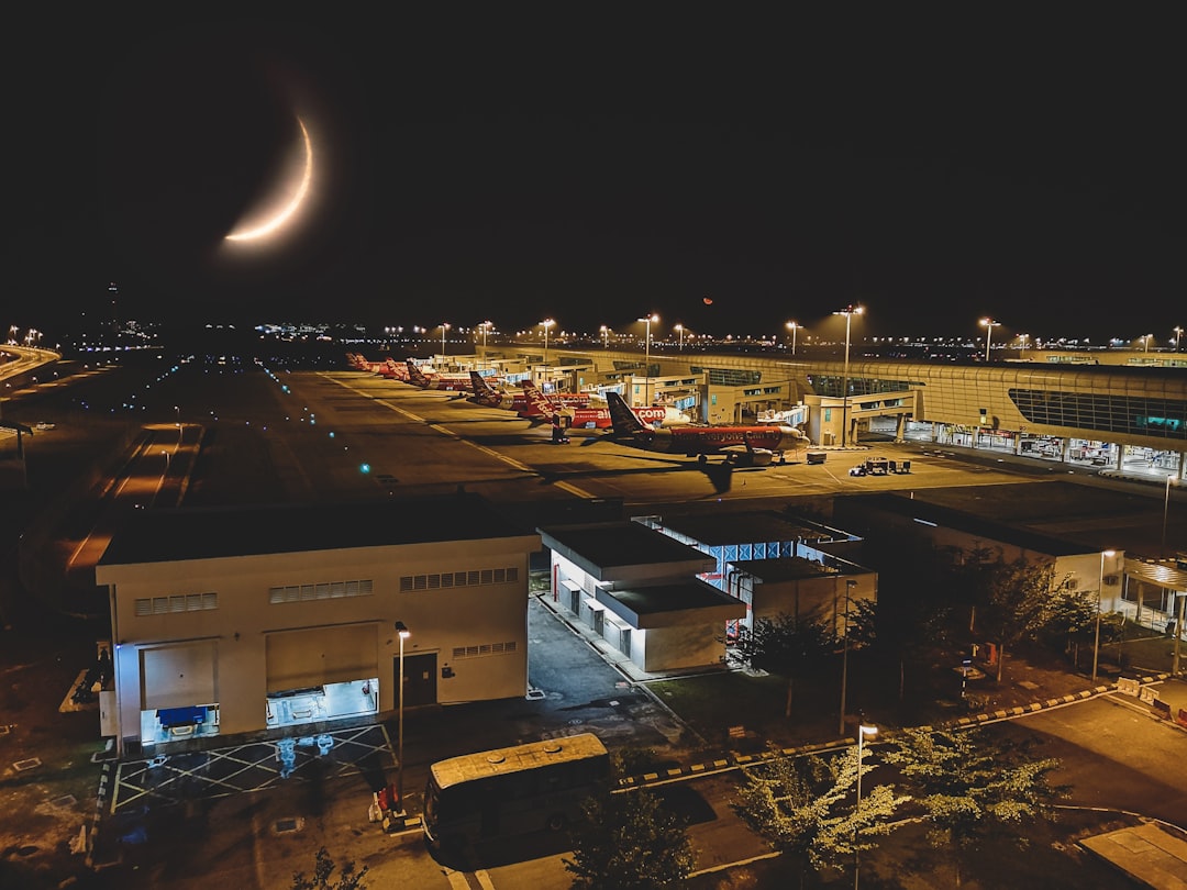 white and black concrete buildings at nighttime, View of KLIA2 from the observation deck near the departure hall