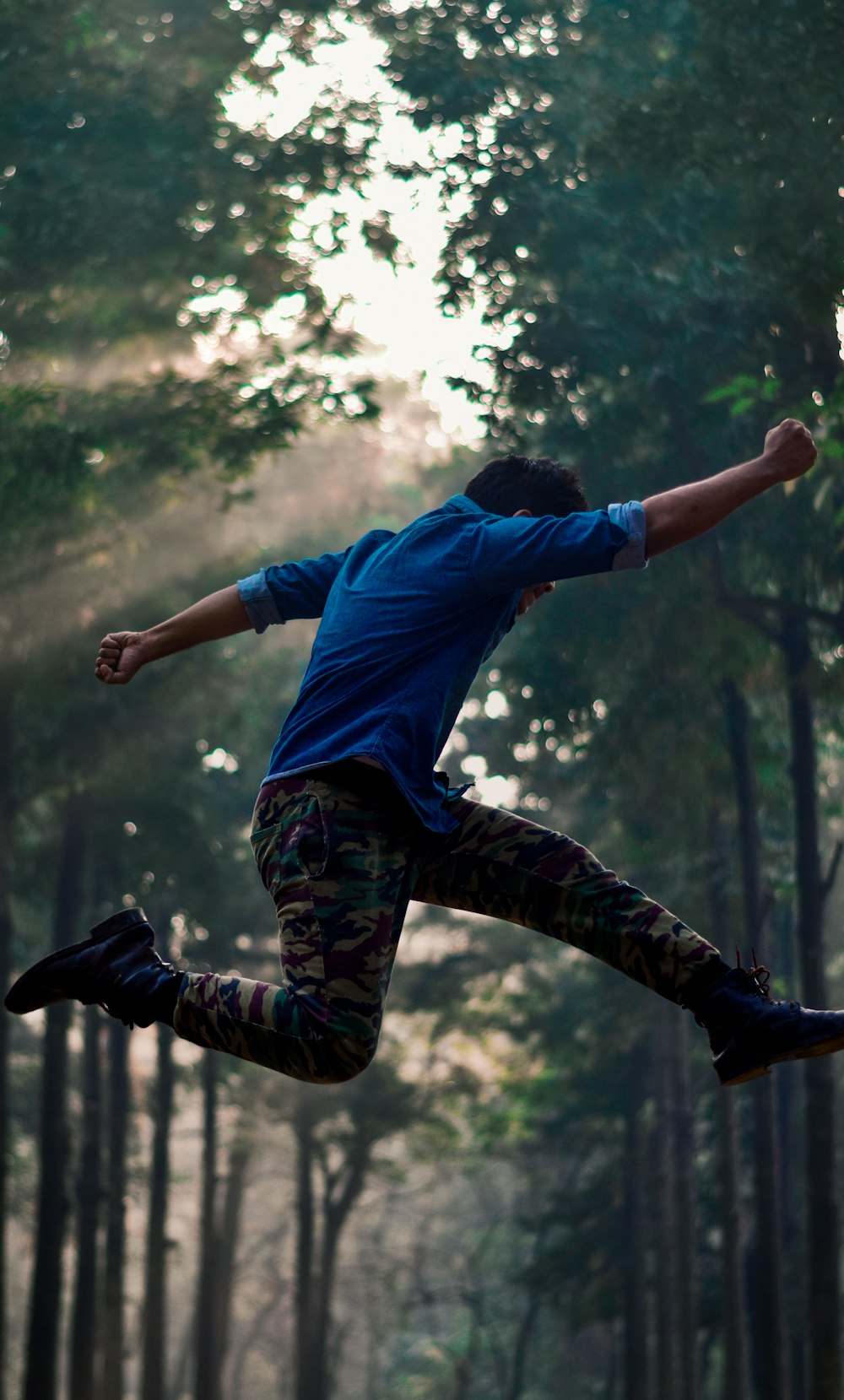 man wearing blue shirt jumping on air during daytime