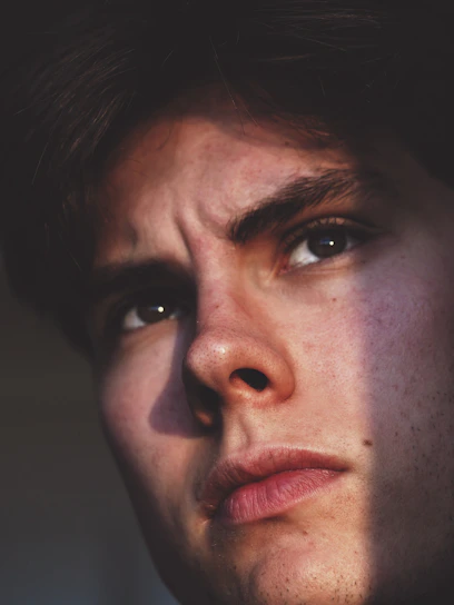 A close-up shot of an actor's intense expression under dim lighting, capturing raw emotion.