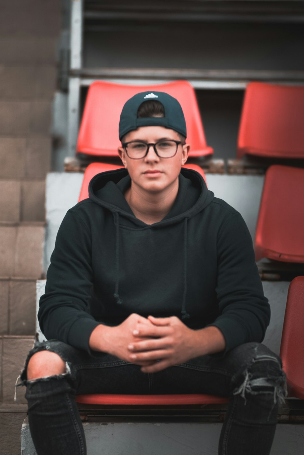 man sitting on bleacher chair