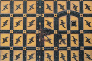 An artisan carefully fitting a decorative iron grille into a wooden door frame