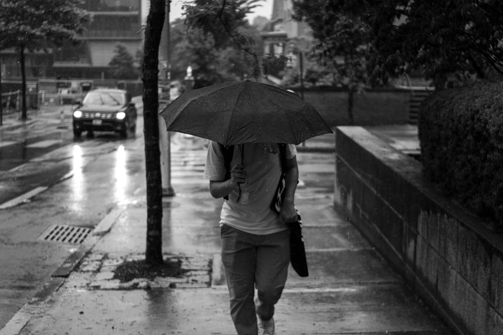 person walking on sidewalk with umbrella