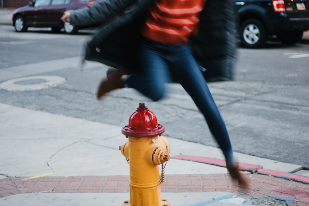 time lapse photography of person jumping over a water hydrant
