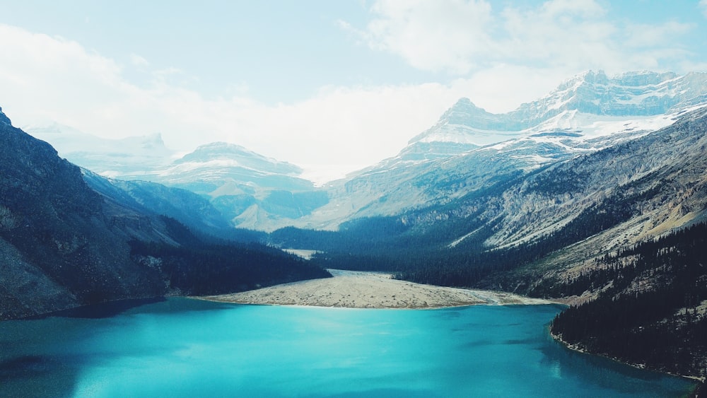 body of water between mountain during daytime