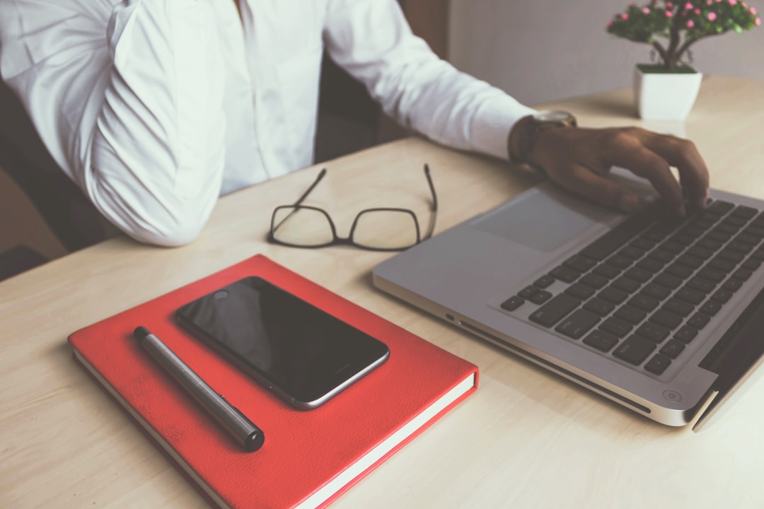 man typing on laptop computer, Stock photo of the Business Man with Notebook, Pen, Mobile and MacBook by rupixen