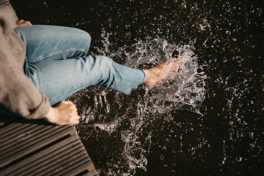 woman wearing blue denim jeans siting on dock