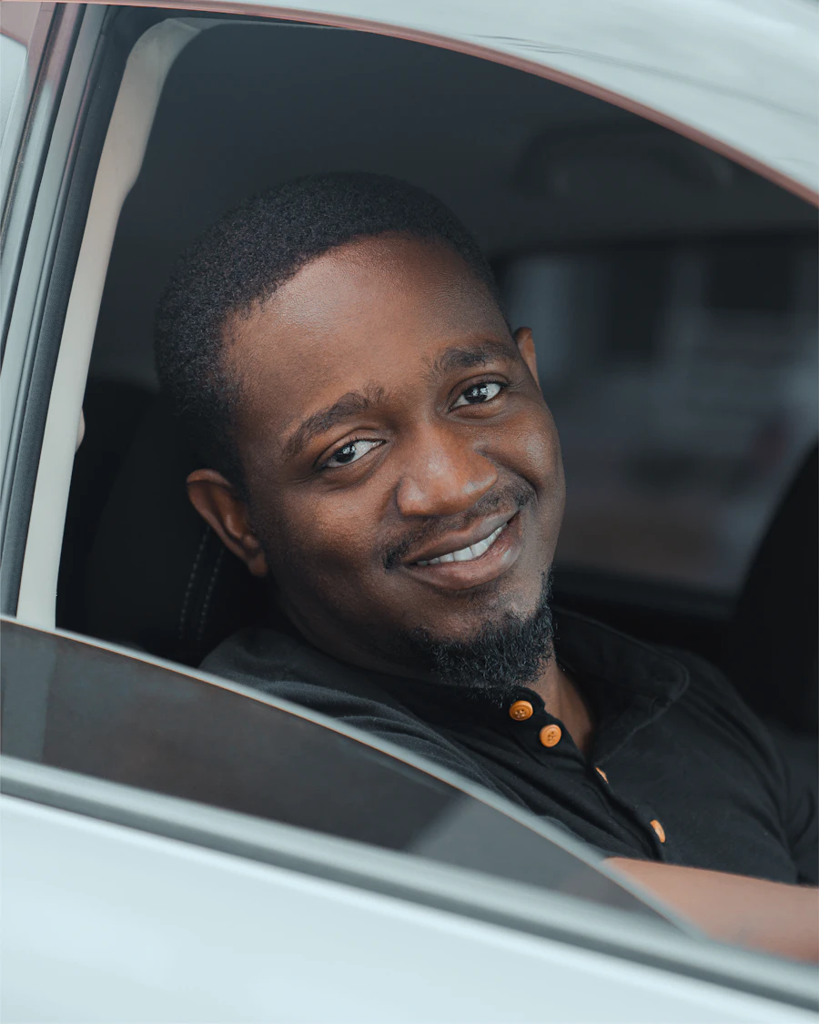 A professional Colat driver smiling from the car