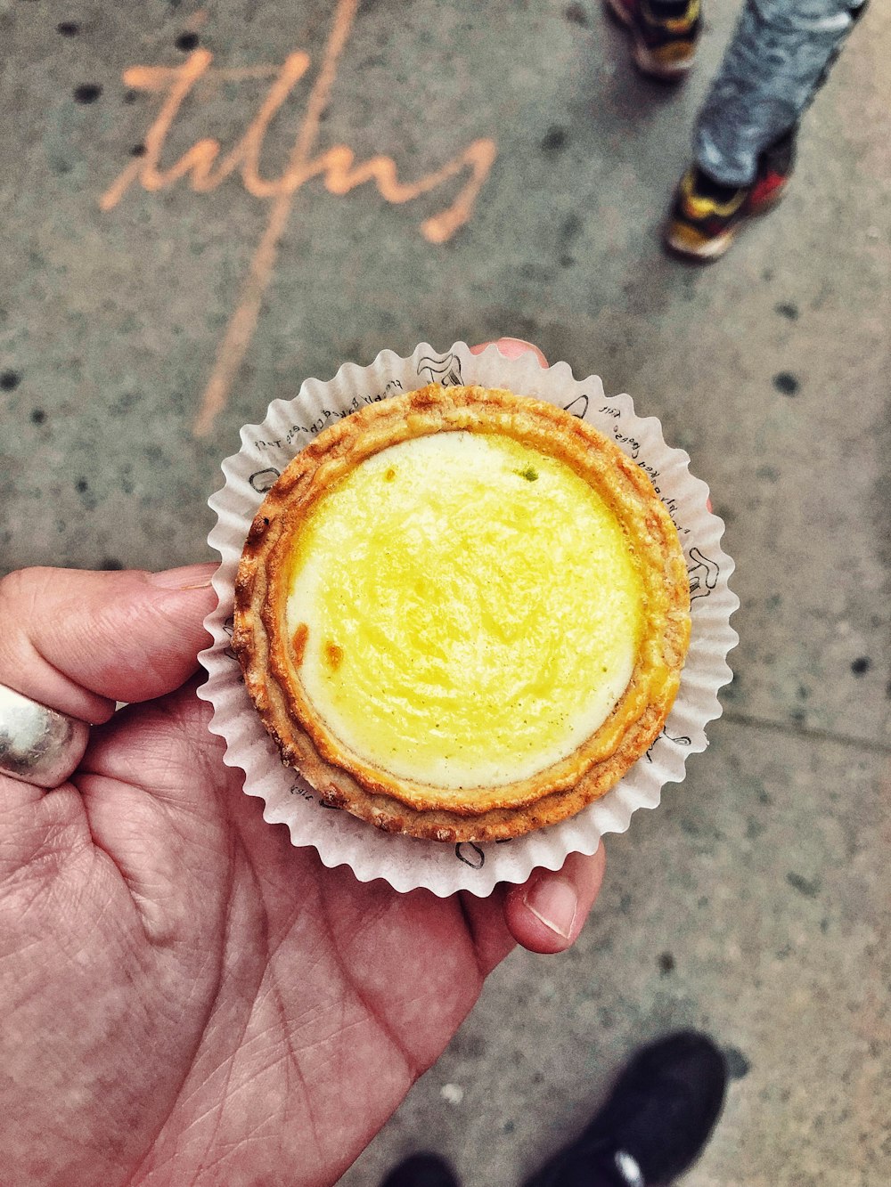 person holding round brown cupcake