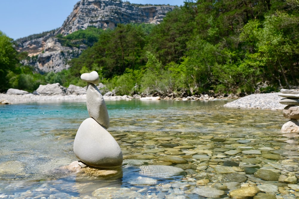 Pedras cinzentas de equilíbrio no rio raso