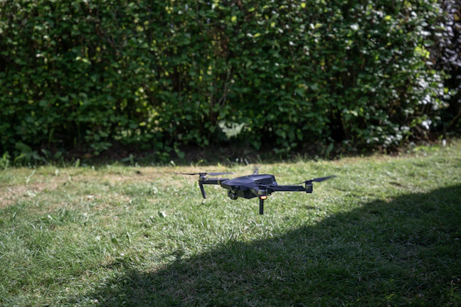 Early morning shot of a drone taking off from a lush green lawn near a beachfront property.