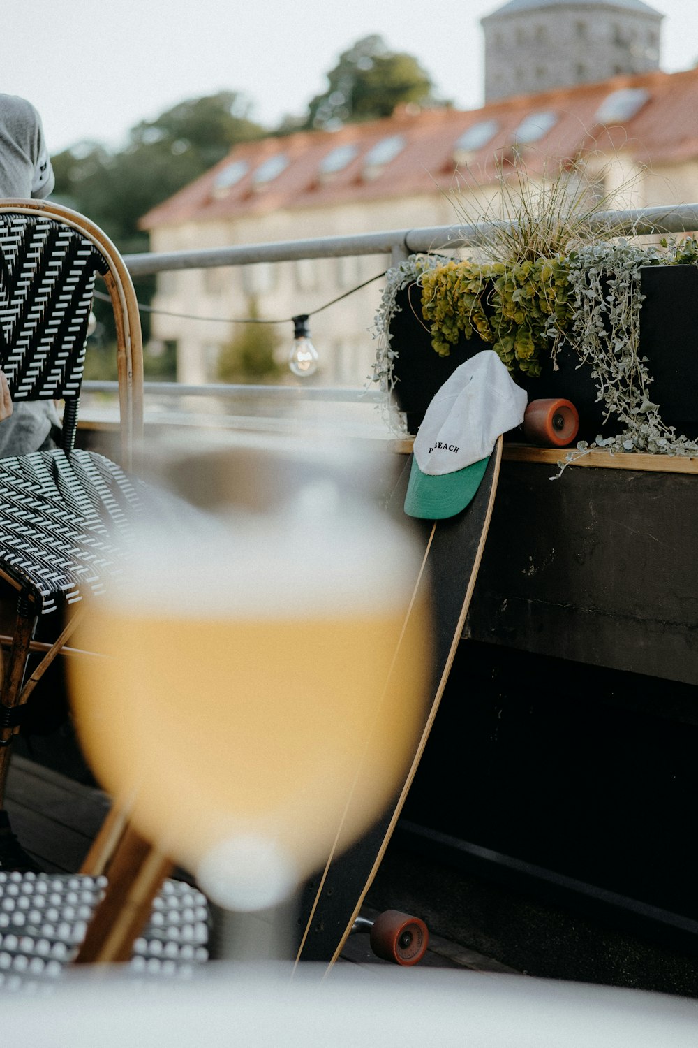 white and green cup on longboard leaning on wall