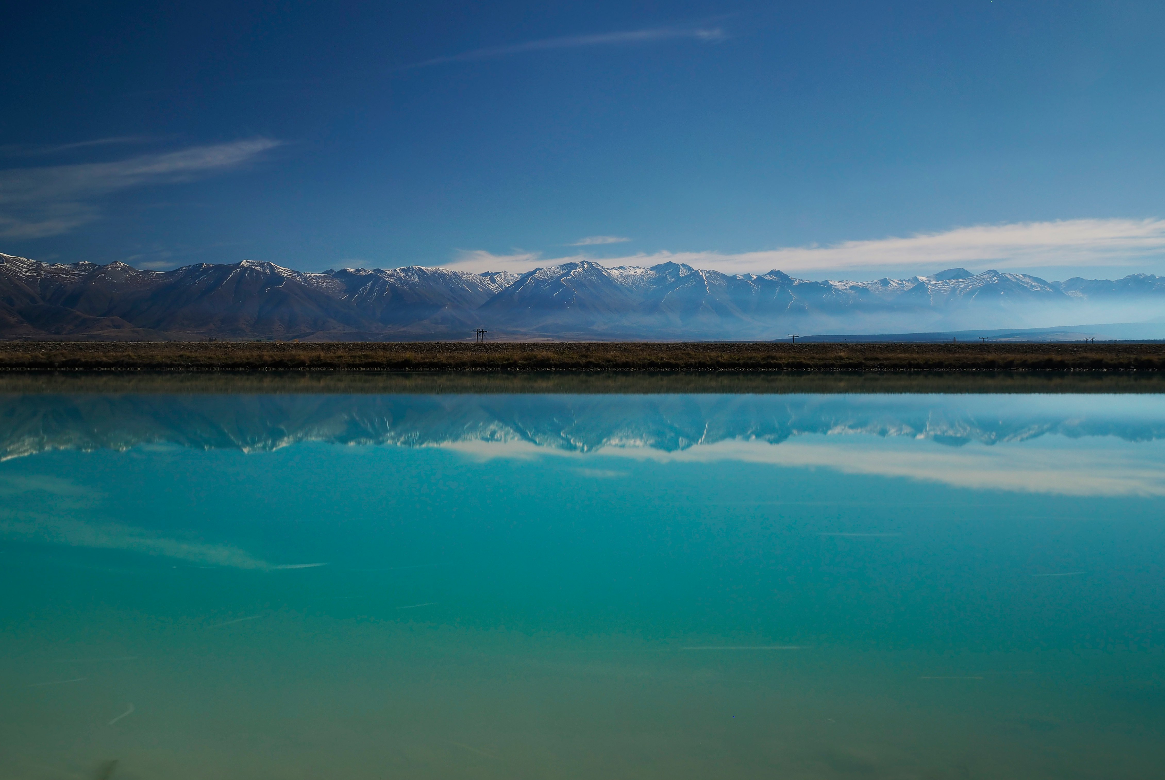 reflective photography of mountain on body of water