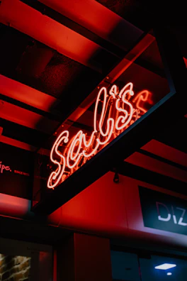 Handcrafted neon-style logo sign glowing brightly in a dim creative workshop