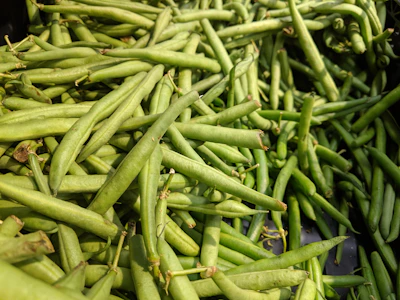 Close-up of colorful fresh beans spilling from a rustic wooden bowl.