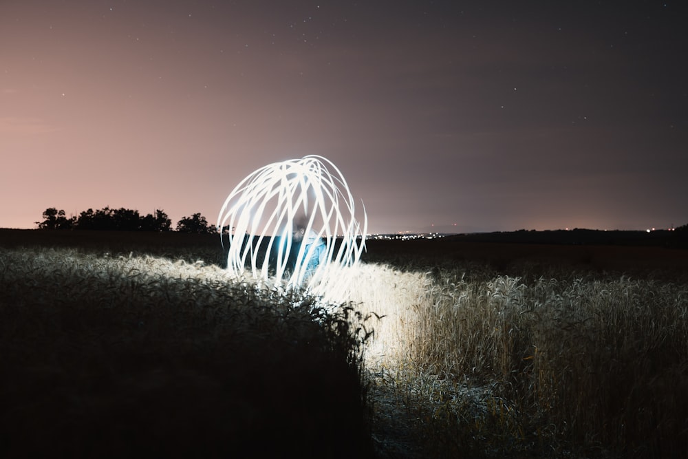 time lapse photography of white lights in a grass field