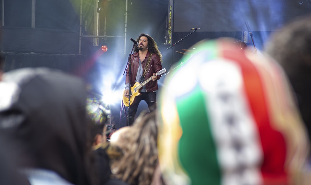 Selektives Foto eines Mannes, der auf der Bühne singt und Gitarre spielt