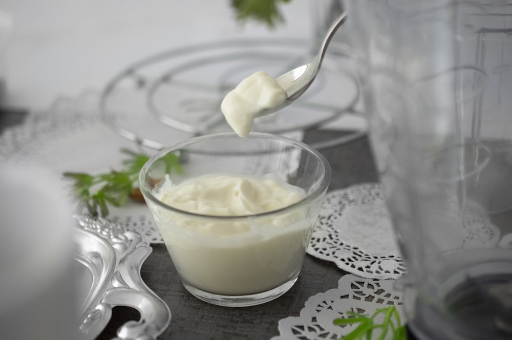 close-up photo of white cream in clear shot glass