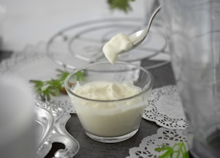 close-up photo of white cream in clear shot glass