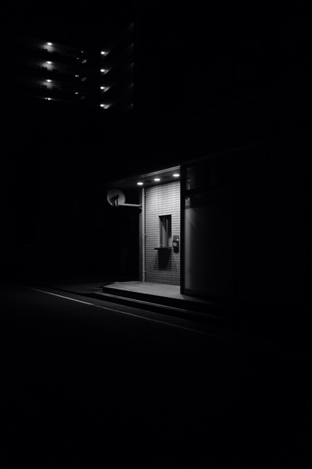 a black and white photo of a door at night