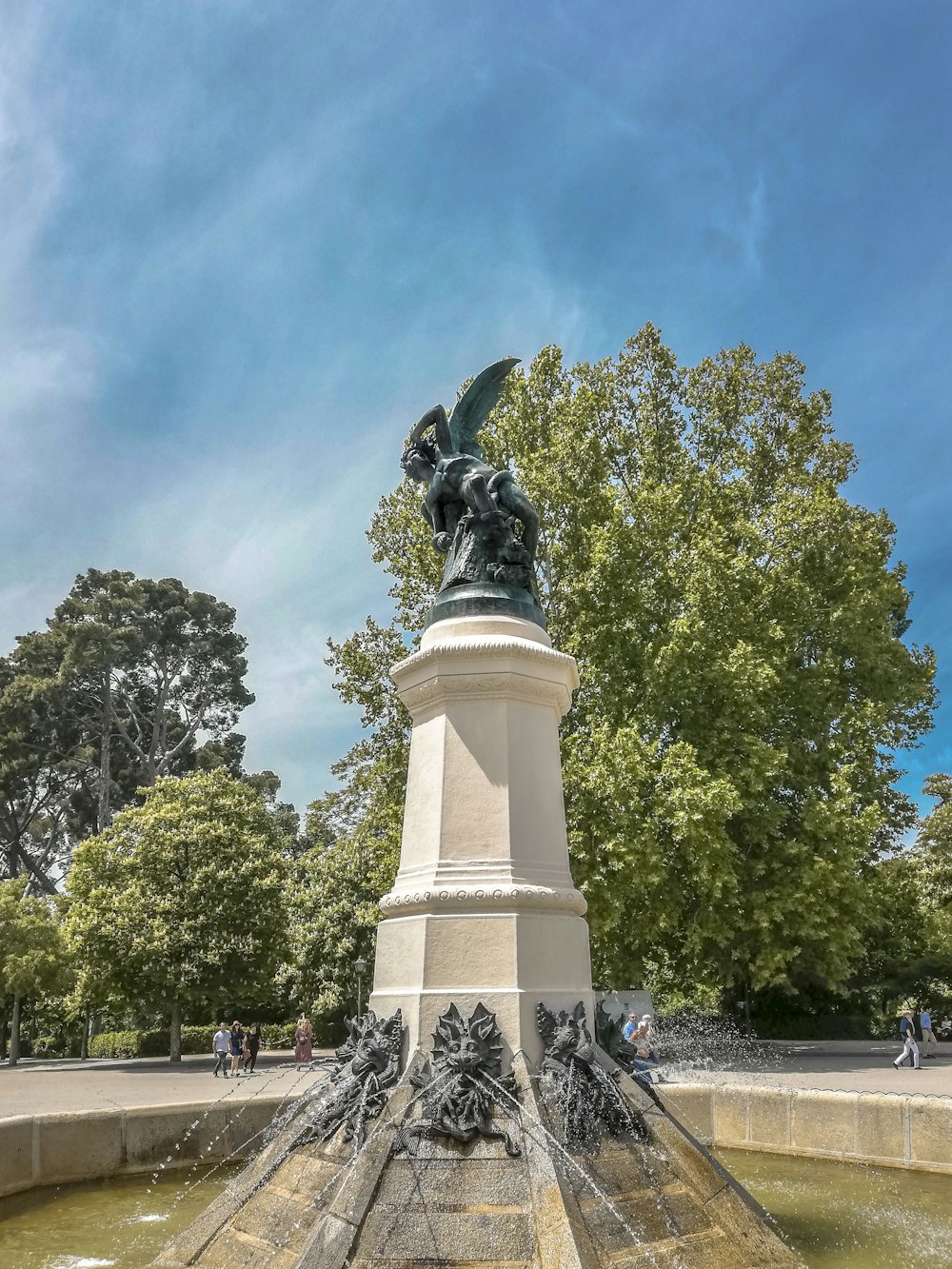 Estátua branca e preta entre a fonte de água