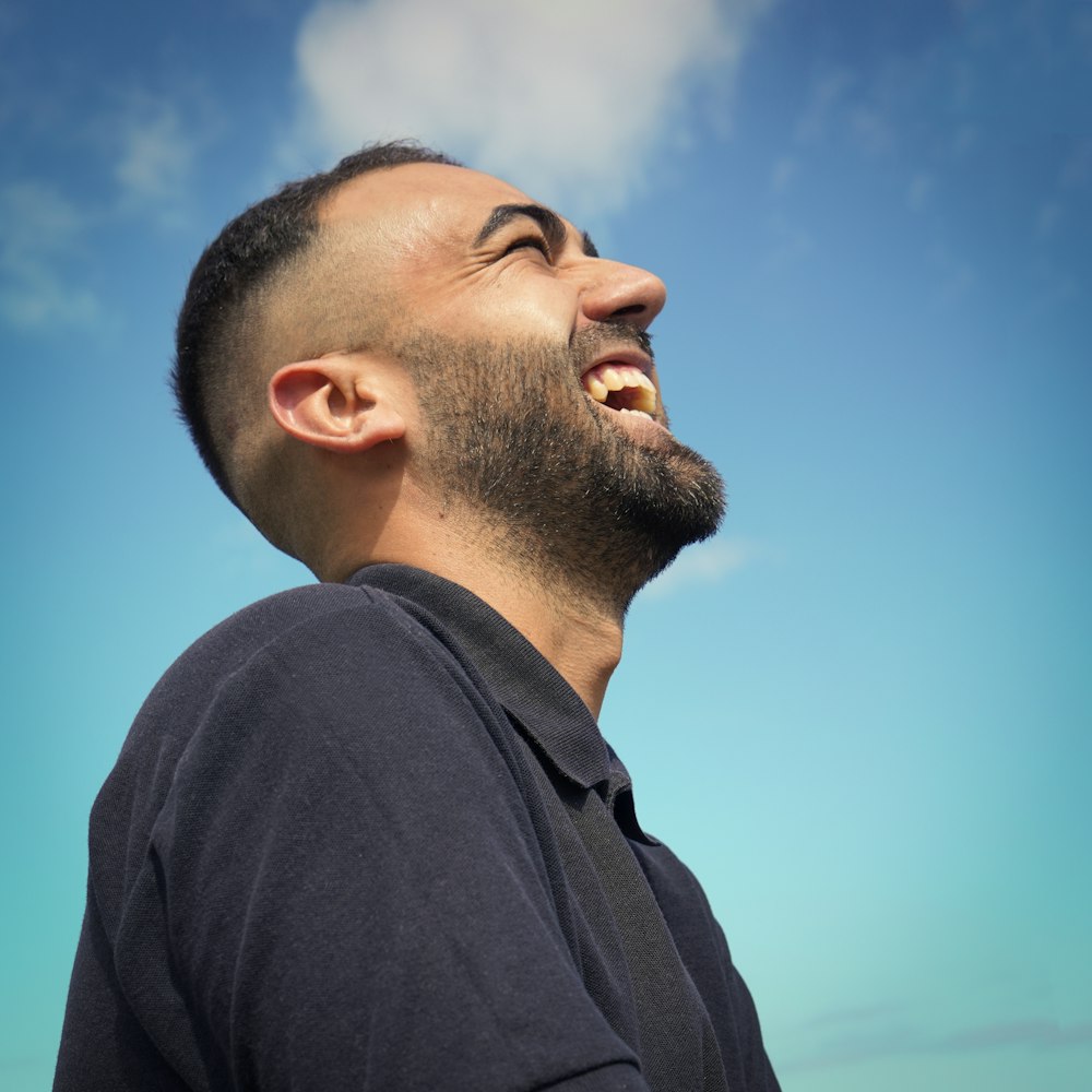 smiling man wearing black collared top