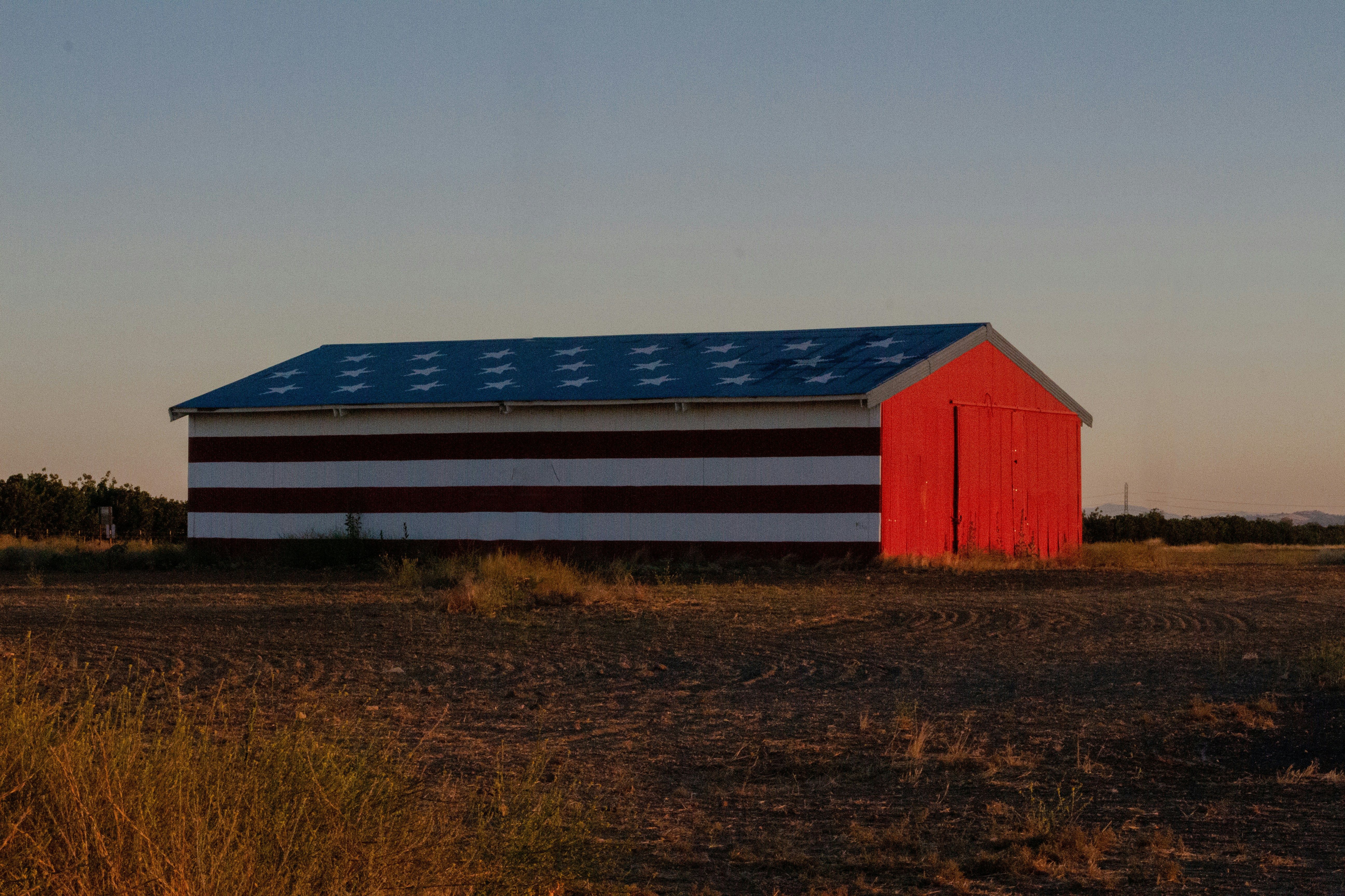 red and white barn during golden hour