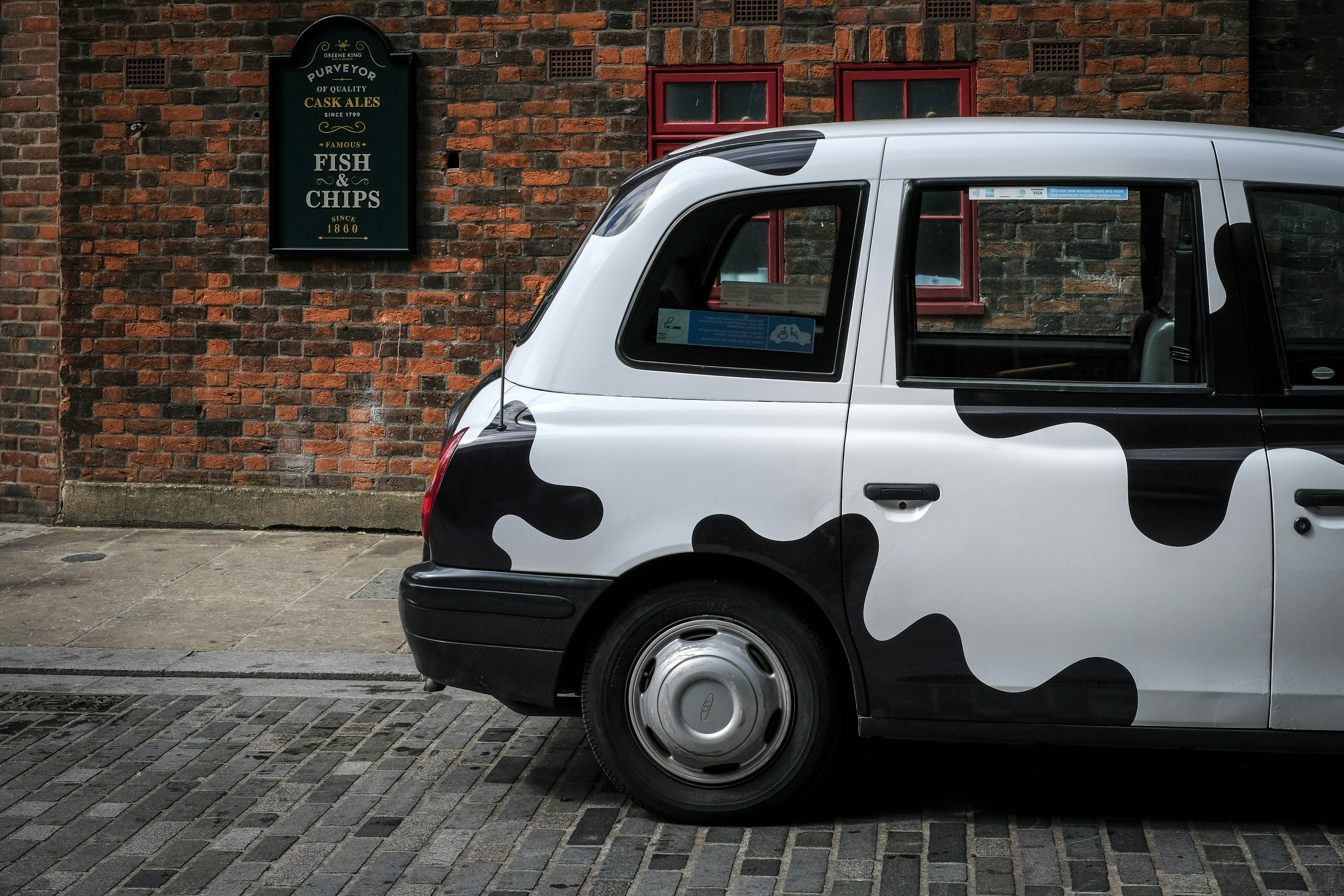 white and black vehicle beside brown building