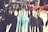 A clothing rack displays a variety of shirts on hangers. The shirts feature different patterns, including polka dots and paisley prints, and appear to be in shades of blue and black. A person's hand is grasping one of the hangers, suggesting selection or browsing.