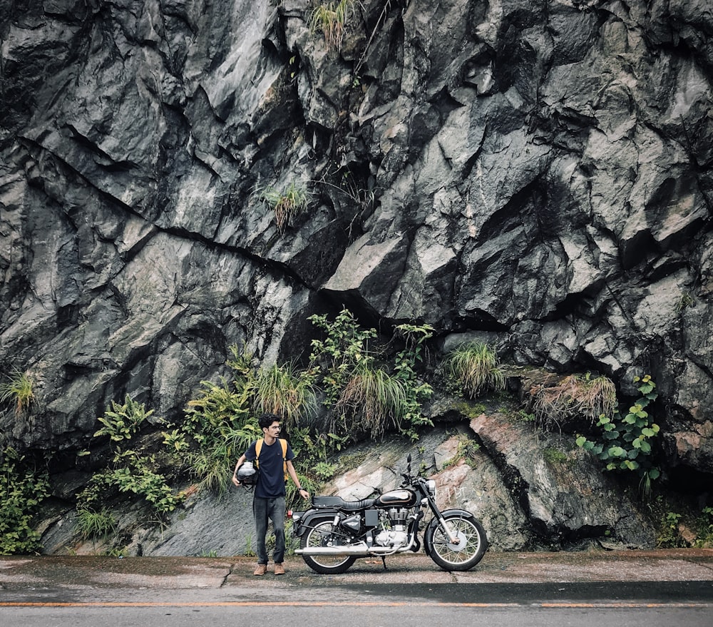 Mann in der Nähe des Motorrads in der Nähe des Berges