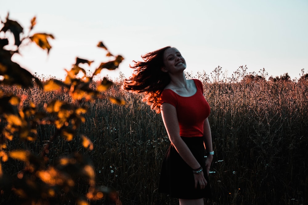 woman standing and smiling while waving her hair