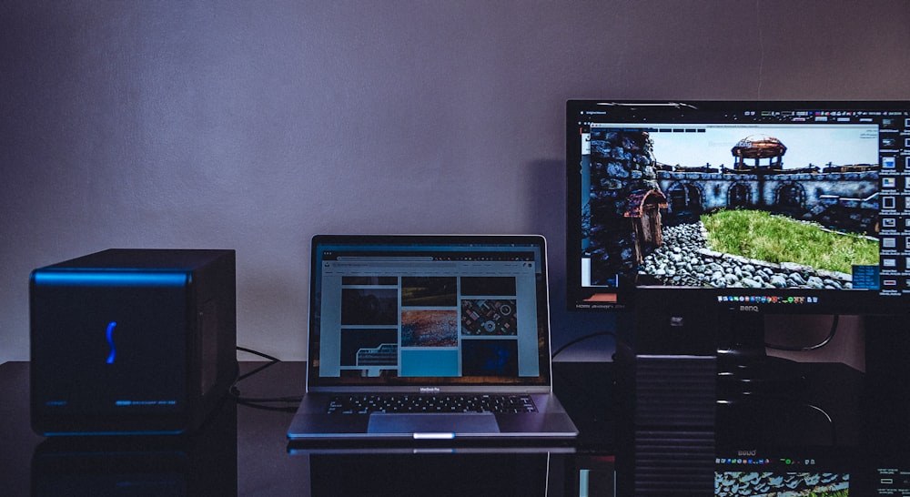 turned-on MacBook beside monitor