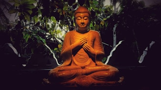 Gautama Buddha figurine near plants