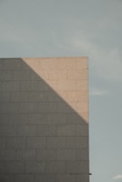 Sturdy block wall forming the foundation of a commercial building under bright daylight.