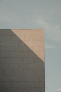Sturdy block wall forming the foundation of a commercial building under bright daylight.