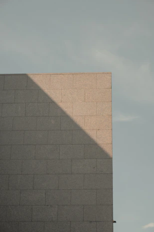 Close-up of clean, precise wall cutting marks on a reinforced concrete wall under bright daylight.