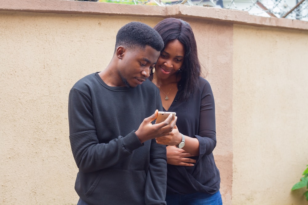 man and a woman looking at a smartphone