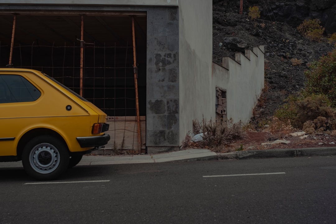 yellow car on road near building