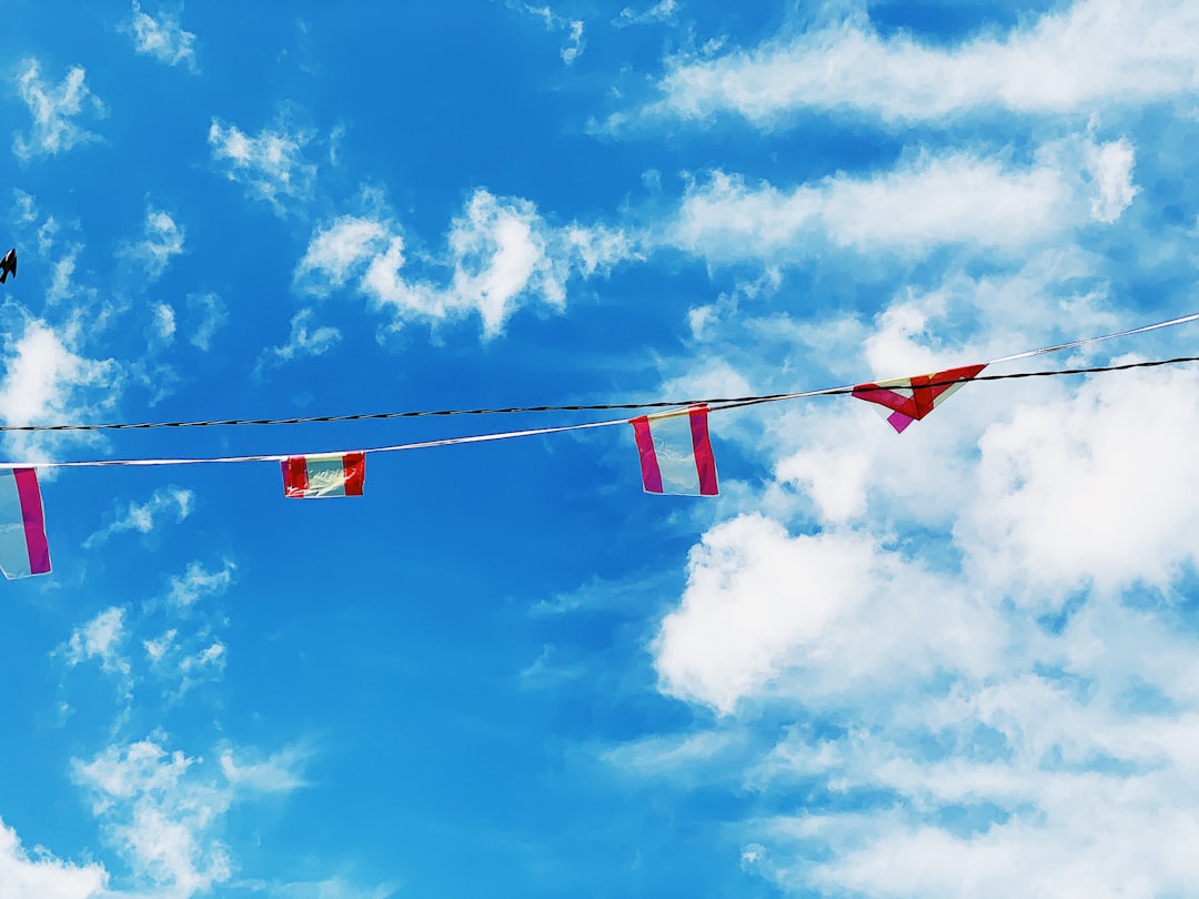 red-and-white flags on string under blue sky