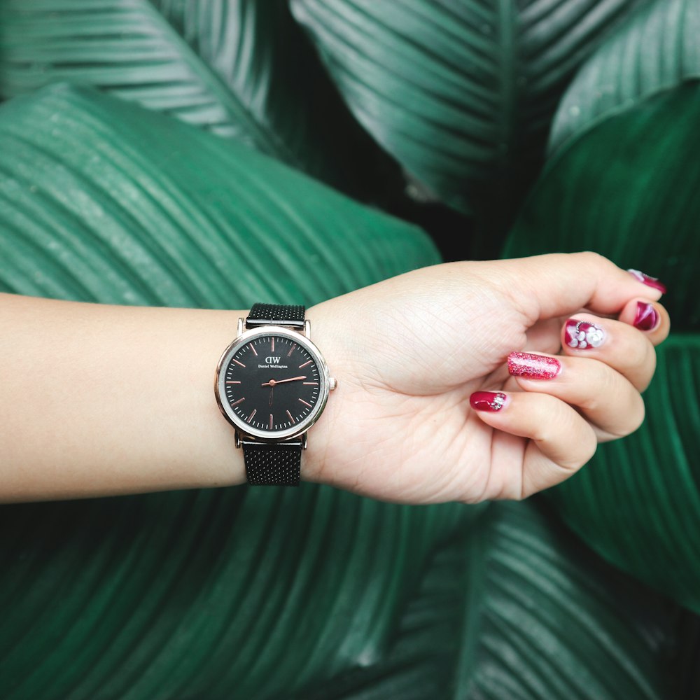 person wearing round silver-colored analog watch