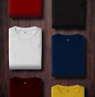 assorted color folded shirts on wooden panel