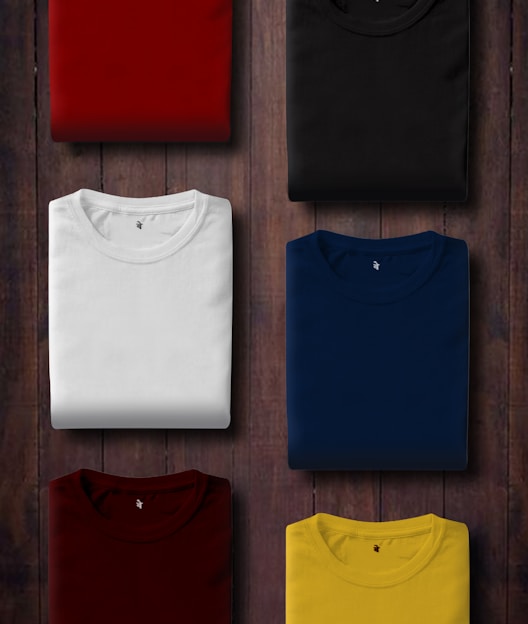 assorted color folded shirts on wooden panel